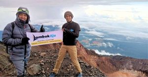 Seorang pendaki berfoto di puncak gunung rinjani saat mengikuti Paket Pendakian Gunung Rinjani