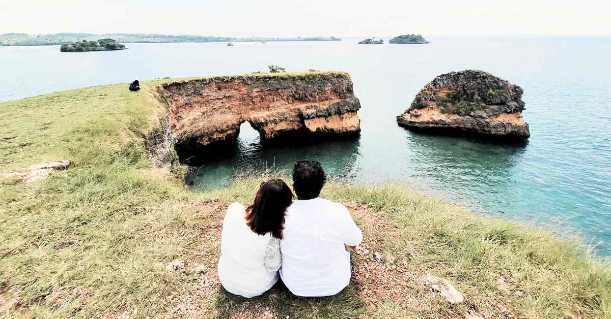 Pasangan berfoto di pantai Lombok saat honeymoon