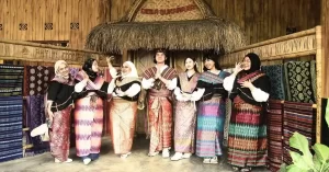 Wisatawan berpose mengenakan pakaian adat Sasak di Desa Sukarara dalam program Sasak Tour Mandalika