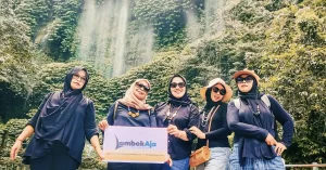 Grup wisatawan wanita berpose ceria di depan Air Terjun Benang Kelambu yang hijau dan alami dalam paket tour Benang Kelambu