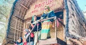 Wisatawan mengenakan pakaian adat Sasak di rumah tradisional Lombok saat mengikuti Paket Wisata Mandalika